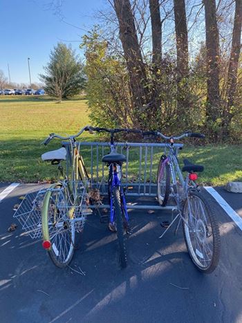 Two bikes are parked next to a bike rack